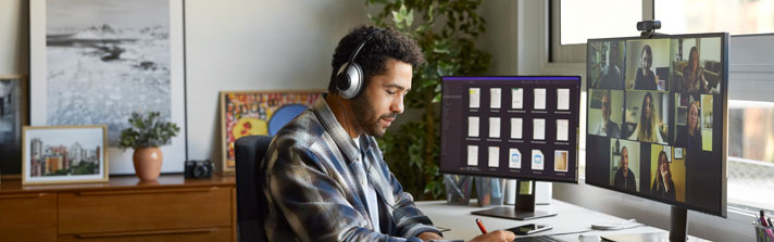A remote worker sits at his desk in his home office.