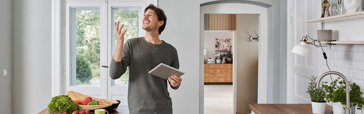 man controls his home smart devices with a tablet