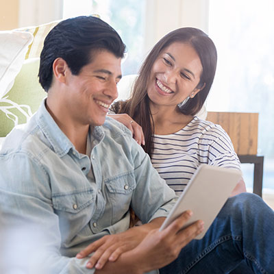 smiling couple reading together on sofa