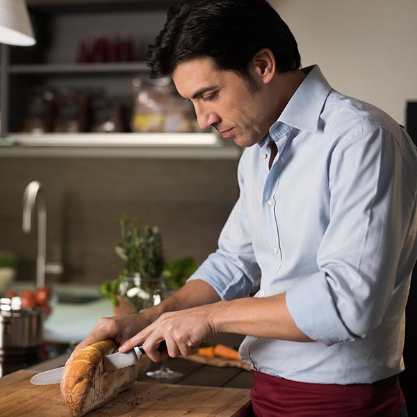 man cutting bread