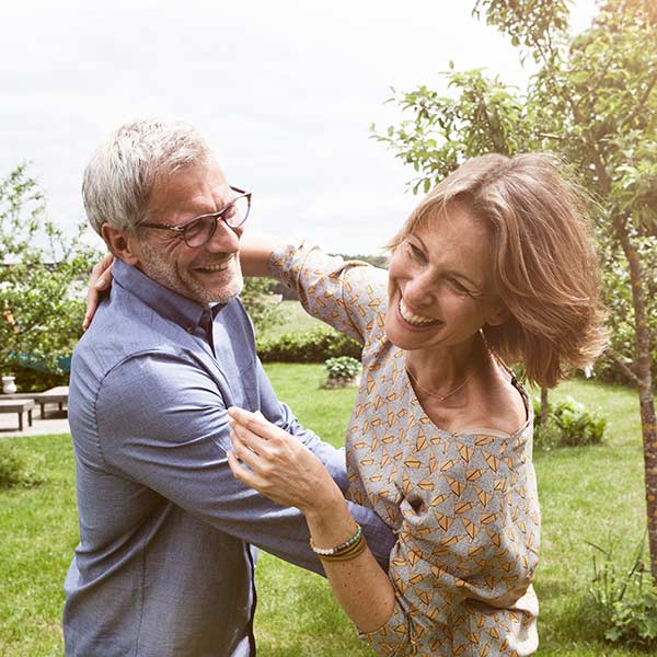 Happy mature couple dancing in garden