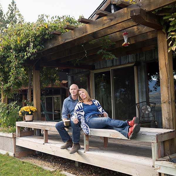 Couple relaxing drinking coffee on patio bench