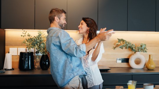 Couple celebrating in the kitchen of their home