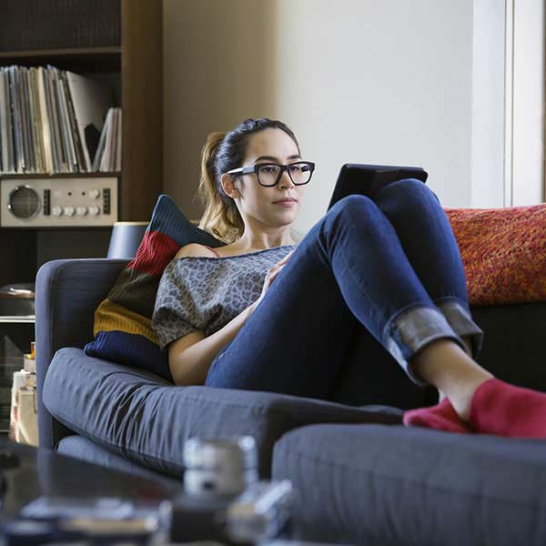 Teenage girl reading on sofa