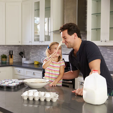 Father and daughter cooking in the kitchen.